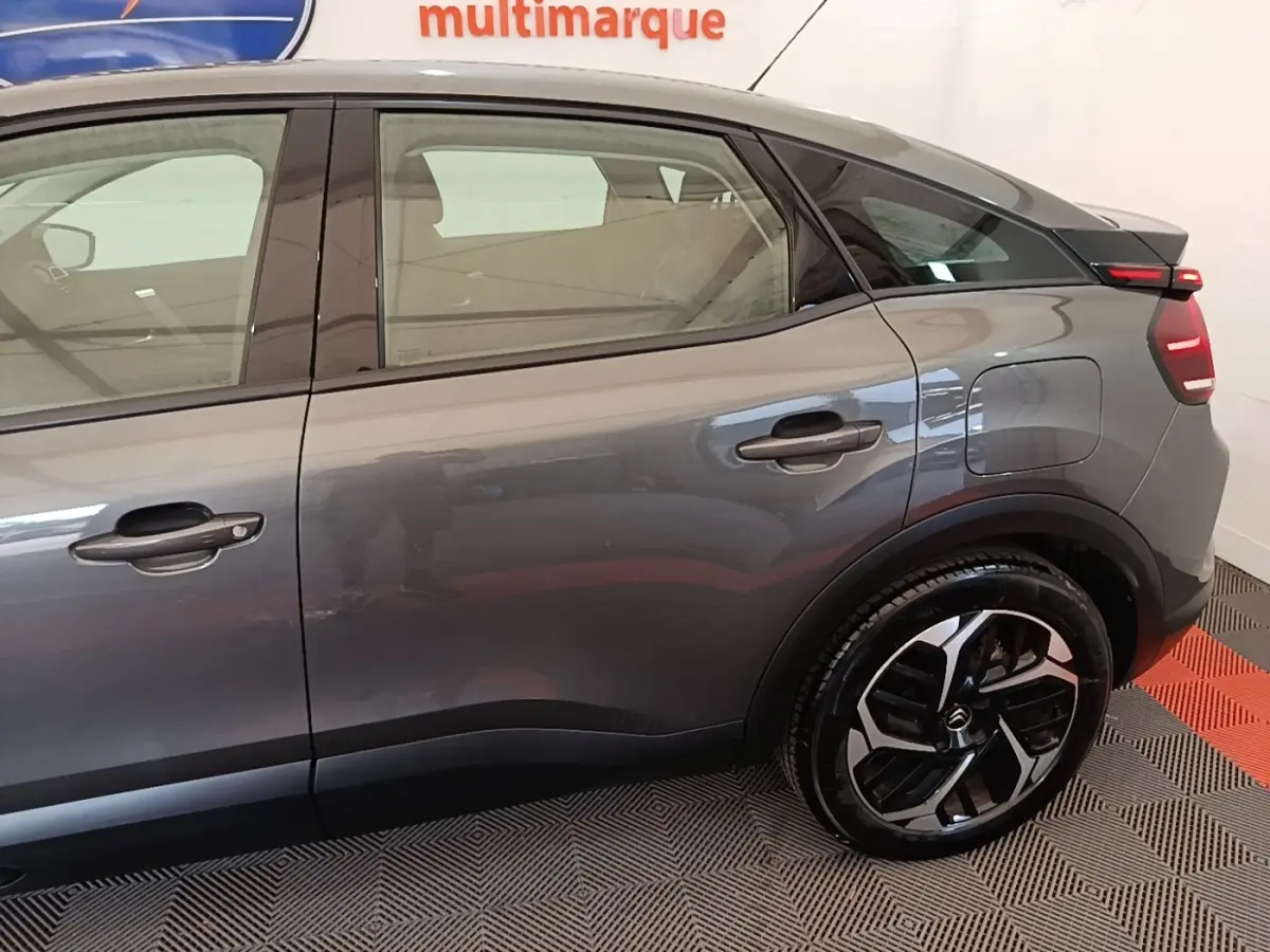Vue latérale droite d'une Citroën C4 gris clair, mettant en valeur la porte arrière et la jante au design moderne.