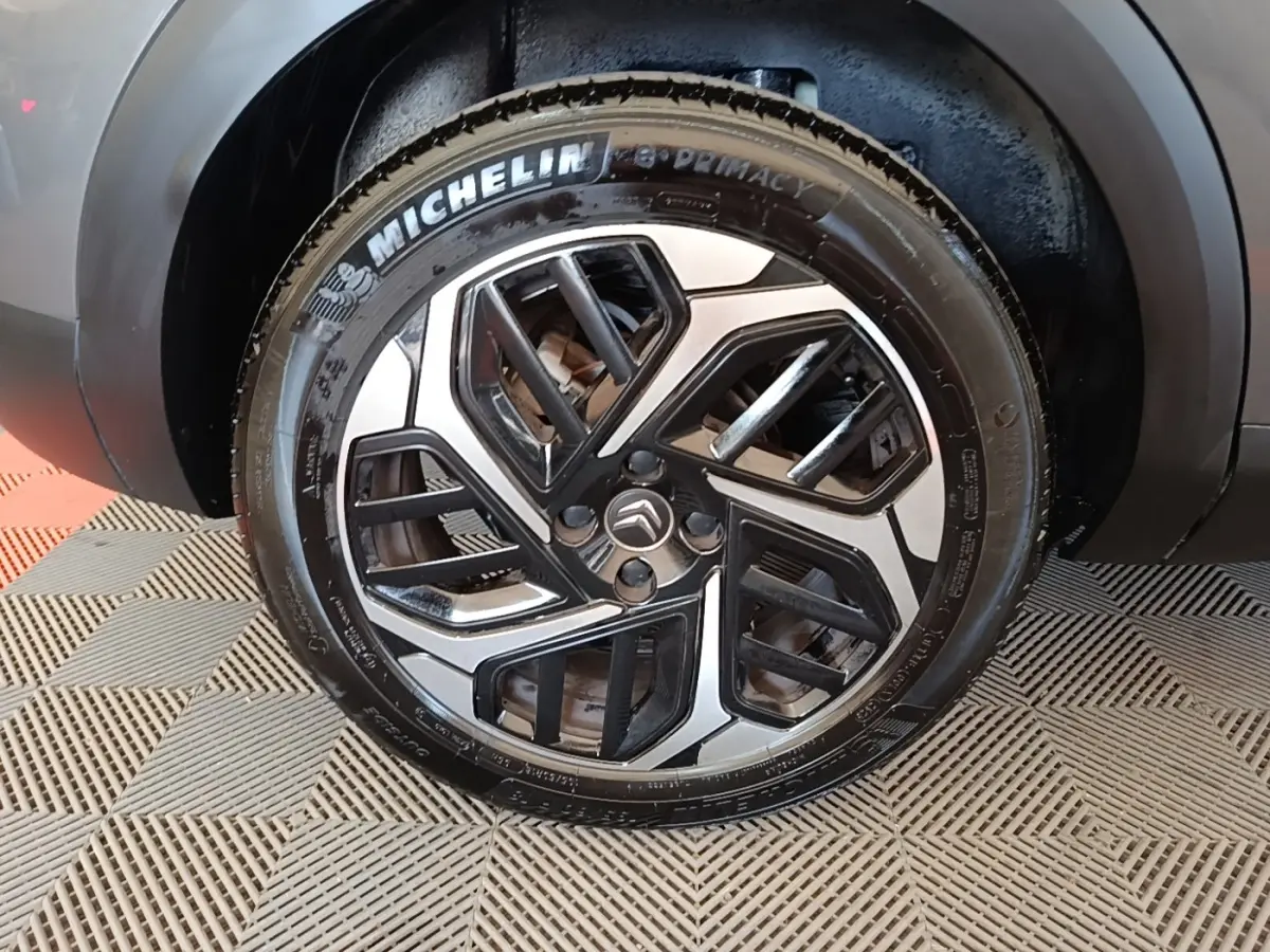 Gros plan sur la roue avant droite d’une Citroën C4 gris clair avec jante alliage et pneu Michelin.