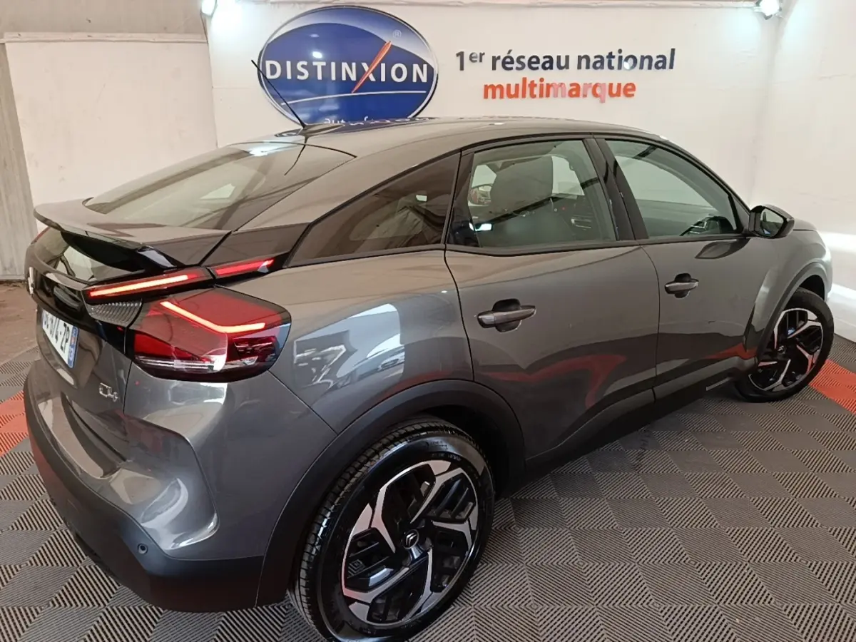 Vue 3/4 arrière droite d'une Citroën C4 gris clair avec feux LED et jantes noires au design moderne.