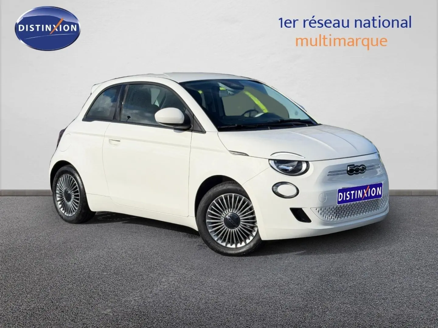 Fiat 500 e 118ch MY24 Ice White pastel vue 3/4 avant droit, avec jantes spécifiques et calandre électrique.