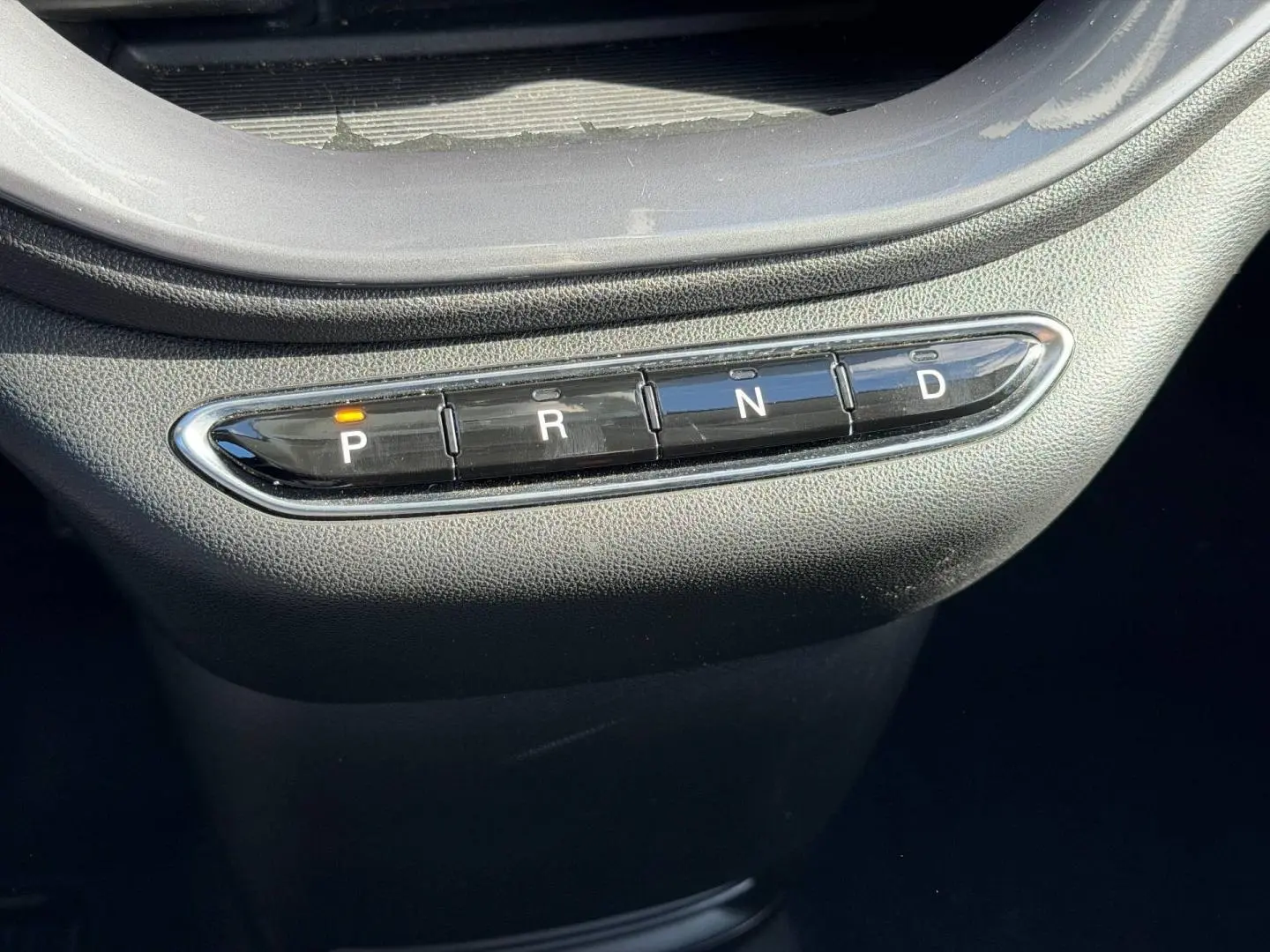 Gros plan sur la commande de boîte automatique avec boutons P, R, N, D dans une Fiat 500 e Ice White pastel 2024.