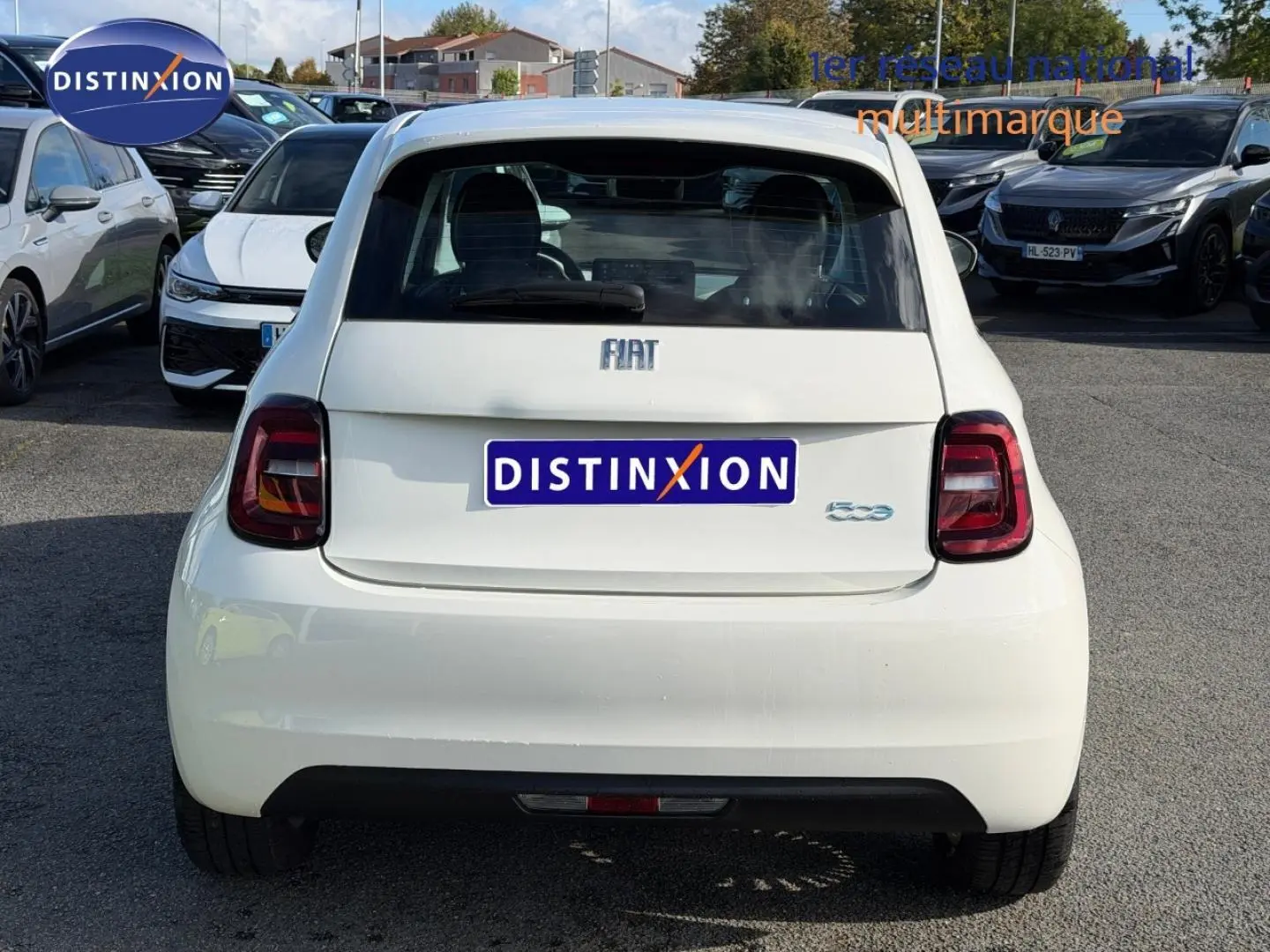 Vue arrière d'une FIAT 500 électrique Ice White pastel 2024, avec feux arrière LED et becquet distinctif.