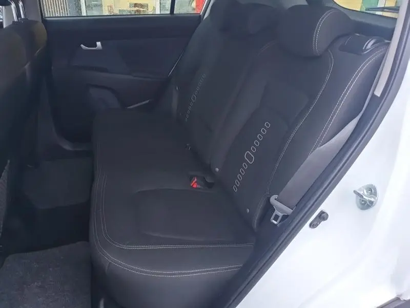 Vue côté gauche de la banquette arrière noire avec surpiqûres blanches du KIA SPORTAGE blanc 2013.