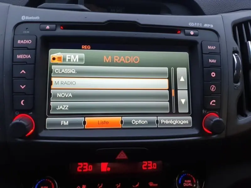 Écran central multimédia du Kia Sportage 2013 affichant les options radio FM avec commandes autour.