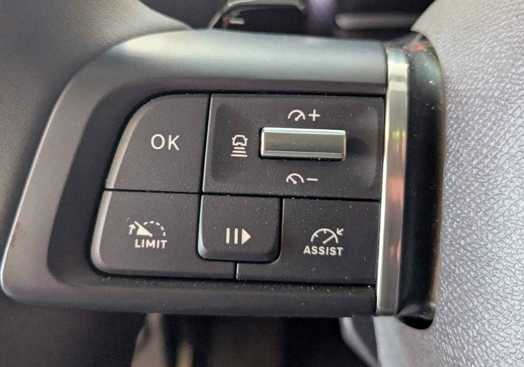 Gros plan sur les commandes noires du volant du Citroën C4 gris platinium, avec boutons de limitation et assistance.