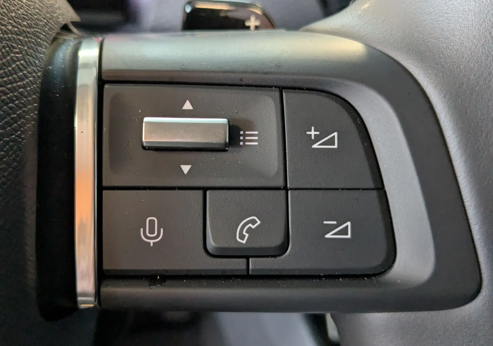 Gros plan sur les commandes vocales et téléphone au volant d'une Citroën C4 gris platinium 2024.