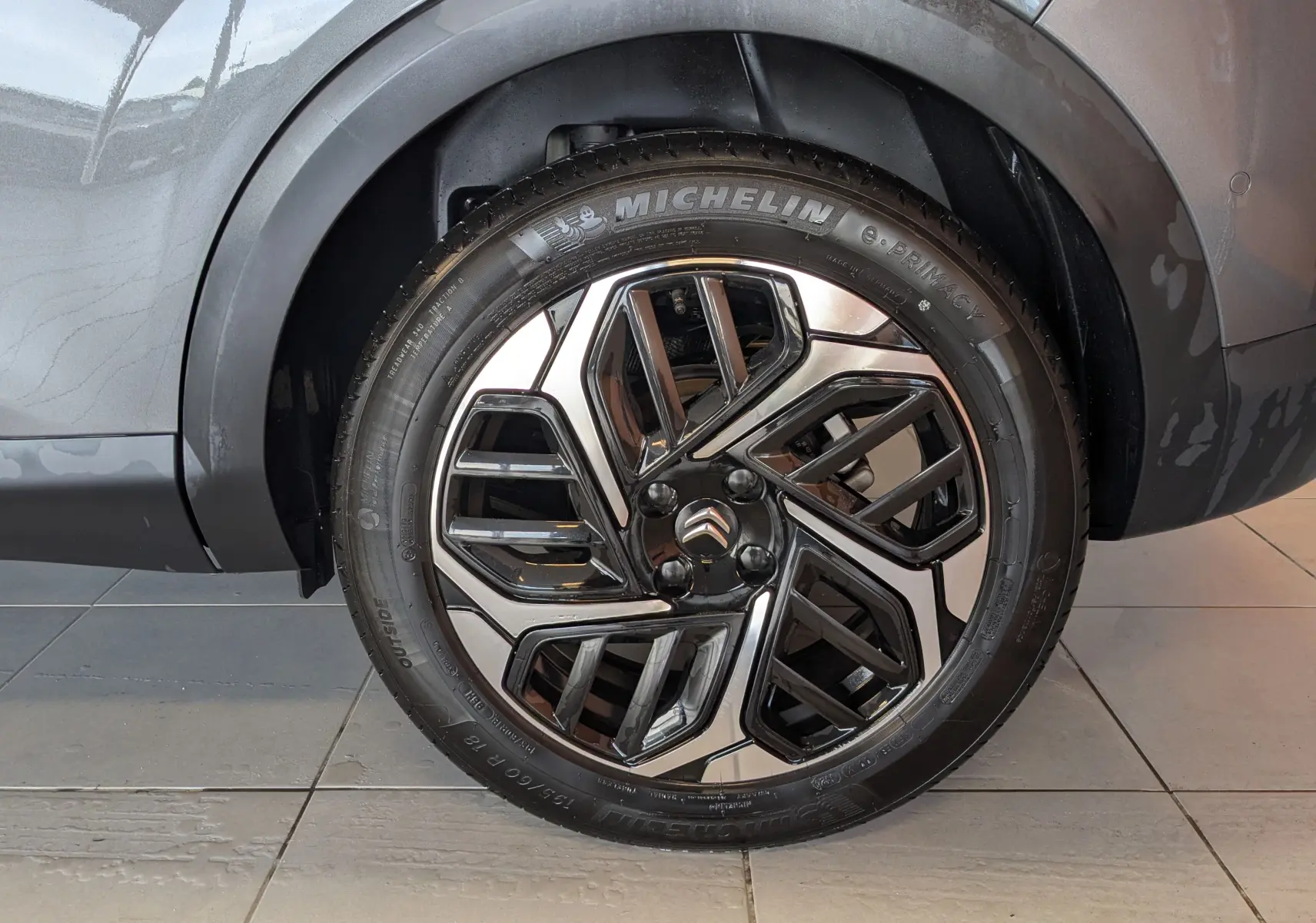 Gros plan sur la roue avant droite d'une Citroën C4 gris platinium avec jante alliage 18 pouces au design moderne.