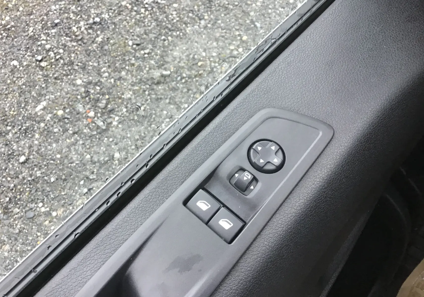 Gros plan sur les commandes de réglage des rétroviseurs et des vitres côté conducteur d’un FIAT Scudo Fourgon blanc.