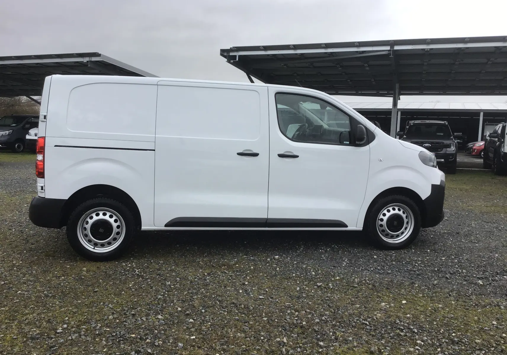 Vue de profil côté droit d’un FIAT Scudo Fourgon blanc 2024 avec garde au sol surélevée et jantes acier noires.