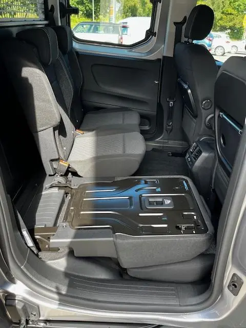 Vue intérieure côté droit du Peugeot Rifter gris foncé 2024, siège arrière droit partiellement rabattu montrant la structure métallique.