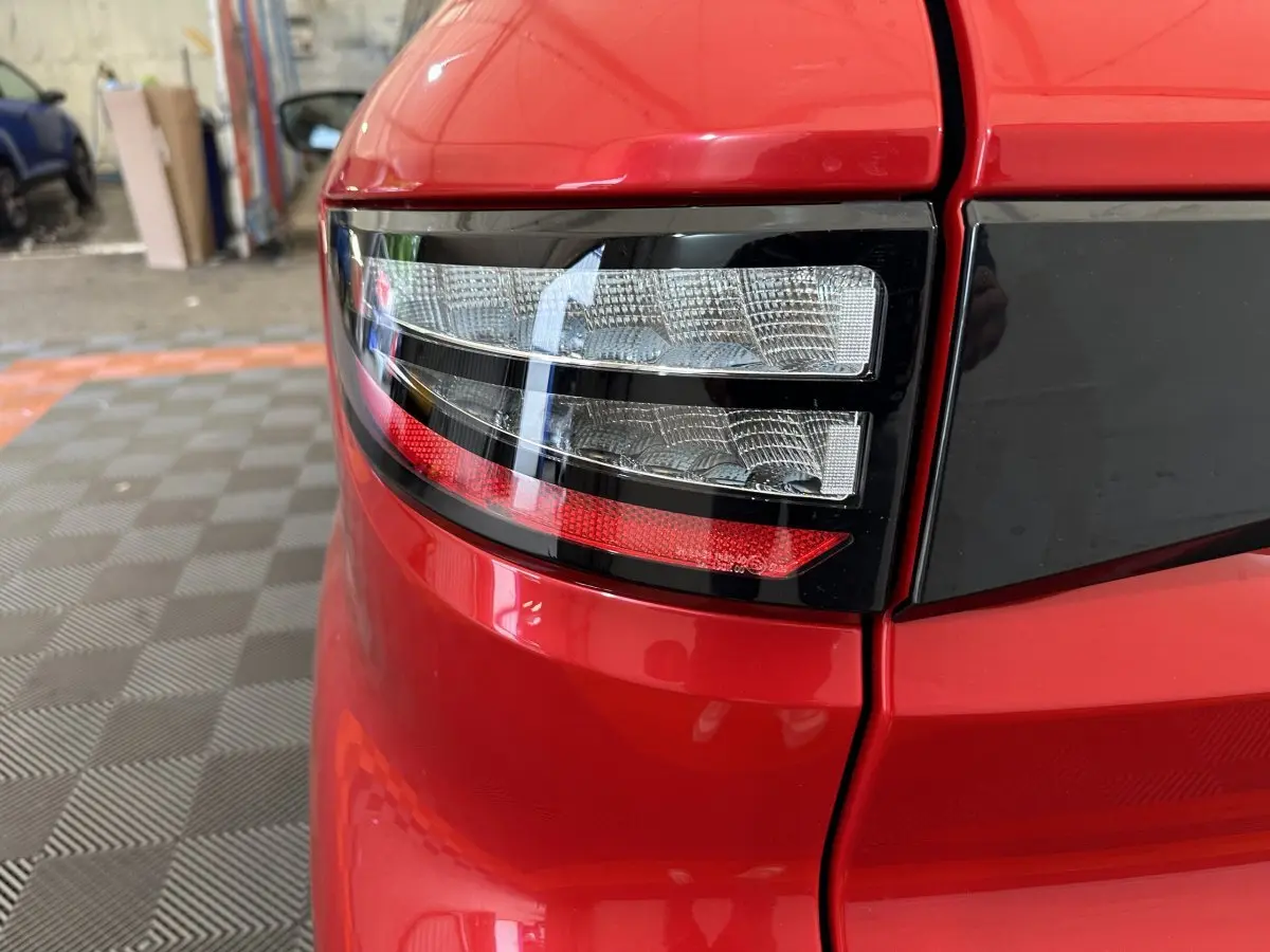 Gros plan sur le feu arrière droit rouge de l’AIXAM AMBITION 0.5 CITY COUPE GTI E5+ 2026 avec détails noirs brillants.