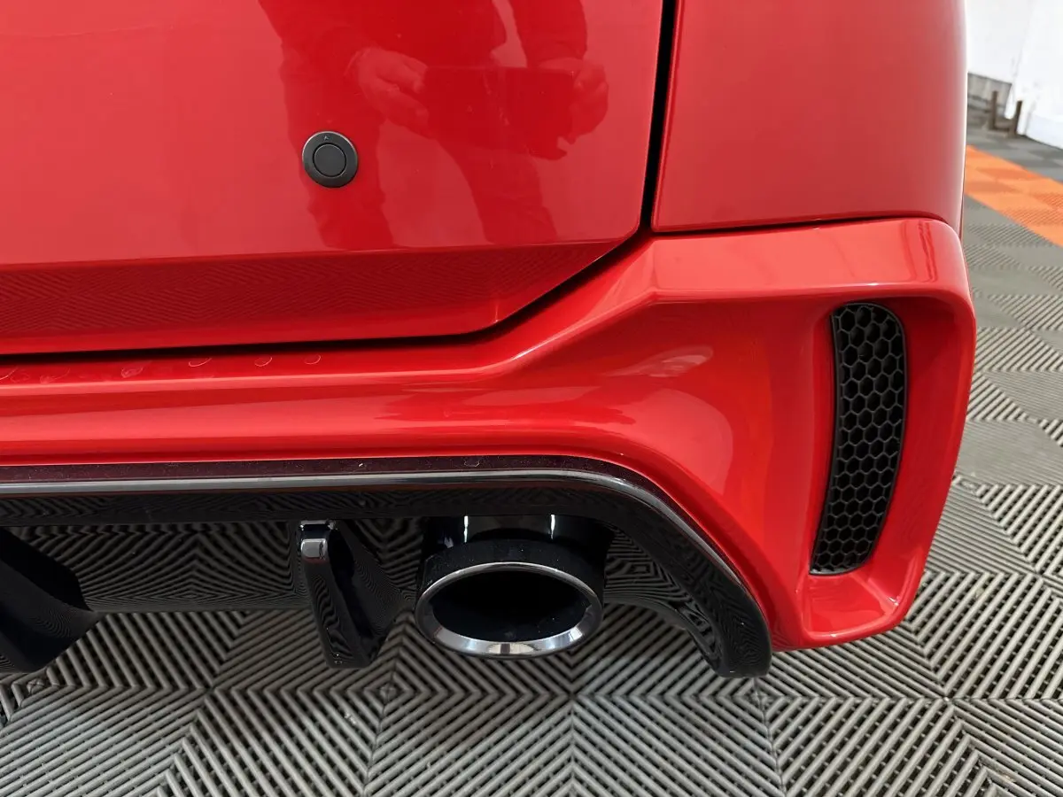 Gros plan sur l’échappement arrière droit rouge de l’AIXAM AMBITION 0.5 CITY COUPE GTI E5+ 2026 avec diffuseur noir.