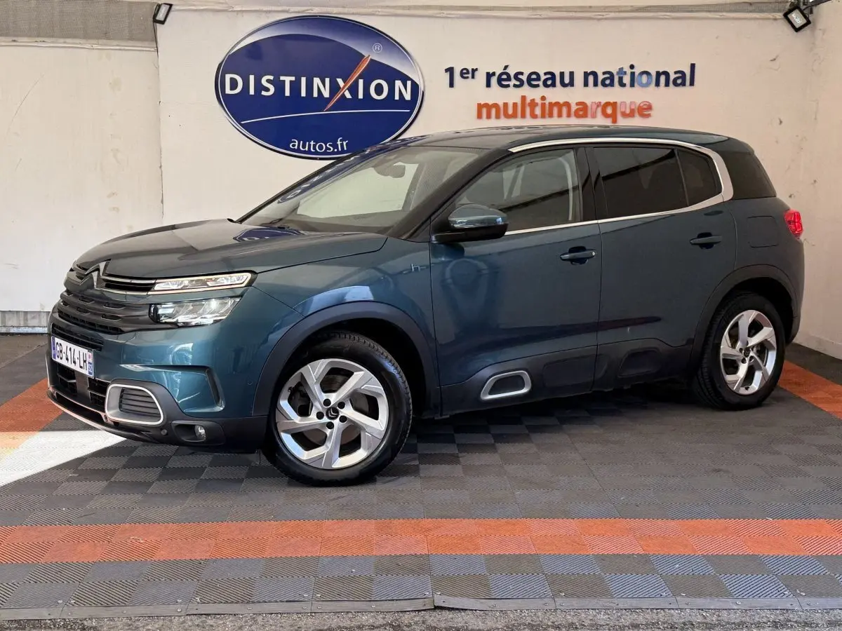 Vue 3/4 avant droit du Citroën C5 Aircross Hybrid bleu avec jantes alliage et signature lumineuse LED distinctive.