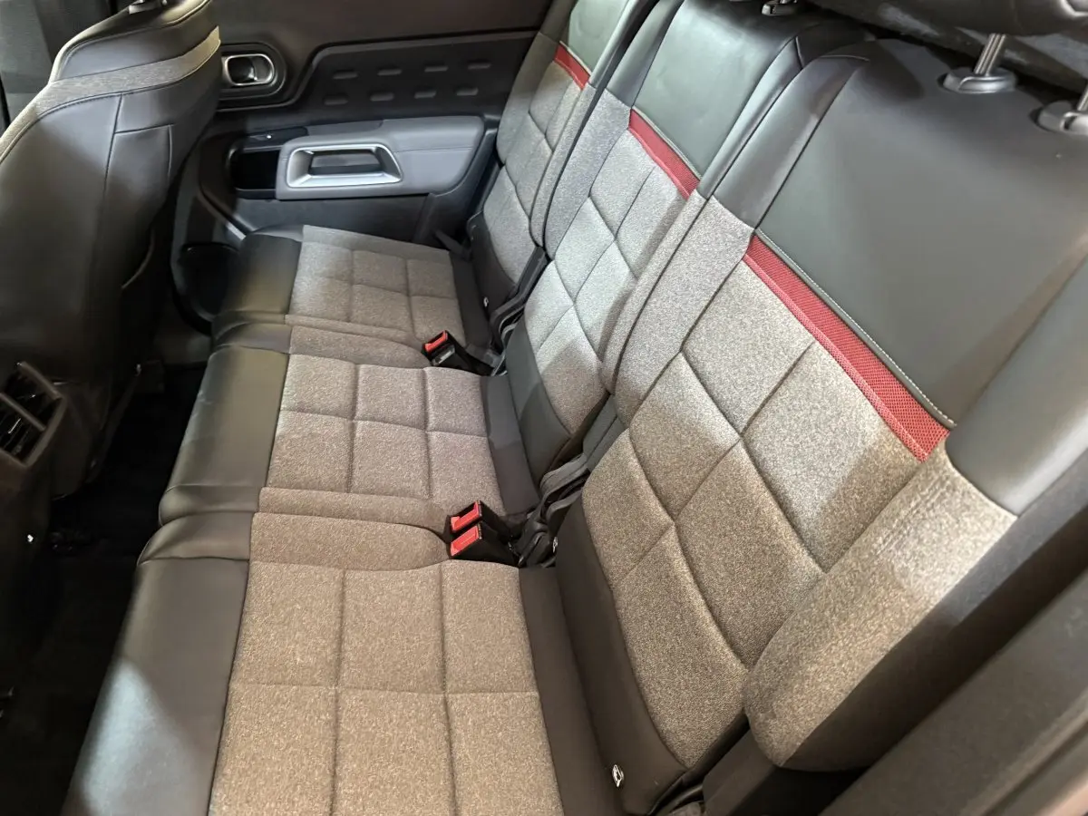 Vue intérieure des sièges arrière en tissu gris et cuir noir avec bande rouge du Citroën C5 Aircross Hybrid 225 ë-EAT8 Business.