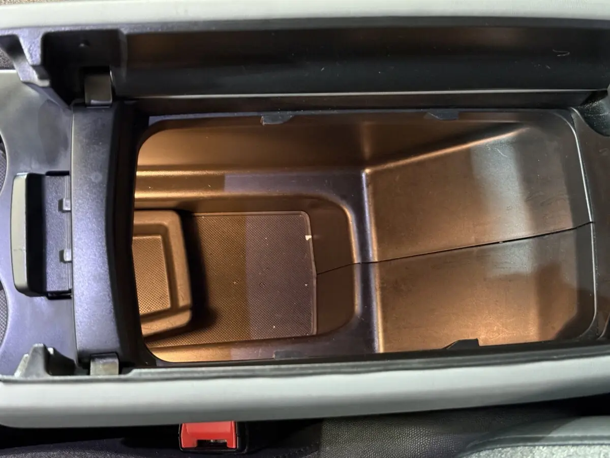 Vue plongeante sur le rangement central intérieur du Citroën C5 Aircross Hybrid 225 ë-EAT8 Business, plastique noir mat.