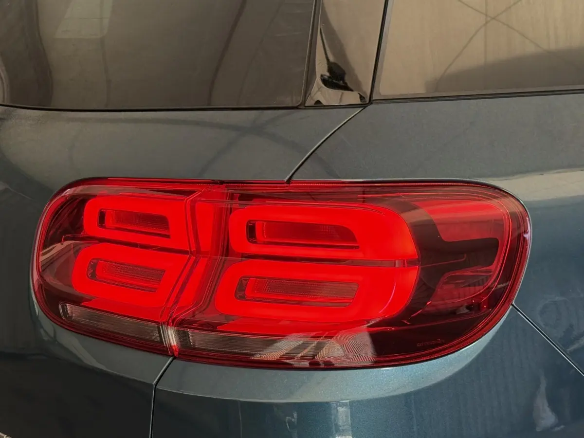 Gros plan sur le feu arrière droit rouge d’un Citroën C5 Aircross Hybrid bleu métallisé.