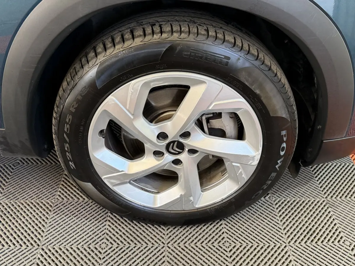 Gros plan sur la roue avant droite du Citroën C5 Aircross Hybrid bleu, mettant en valeur la jante alliage et le pneu Pirelli.
