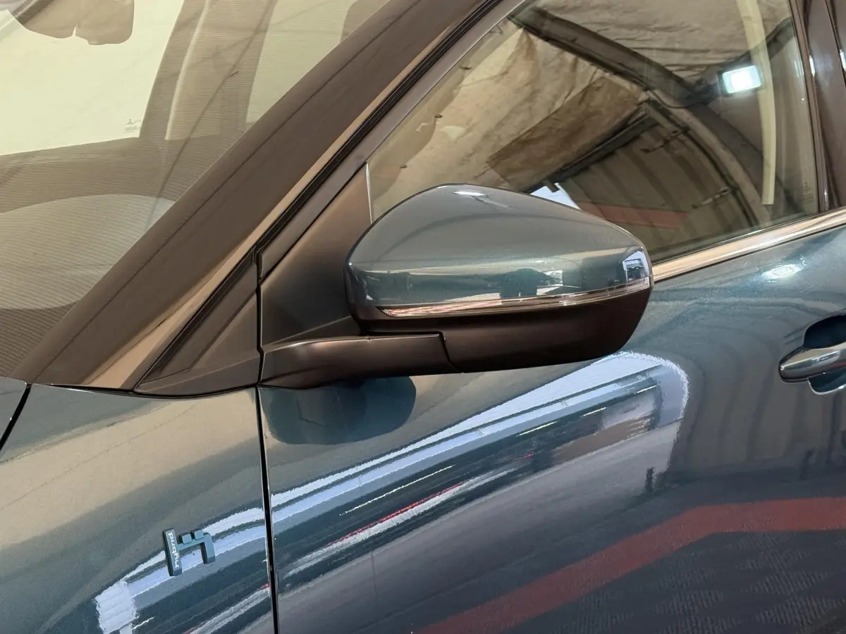 Gros plan sur le rétroviseur droit bleu métallisé du Citroën C5 Aircross Hybrid 225 ë-EAT8 avec badge Hybrid visible sur la portière.