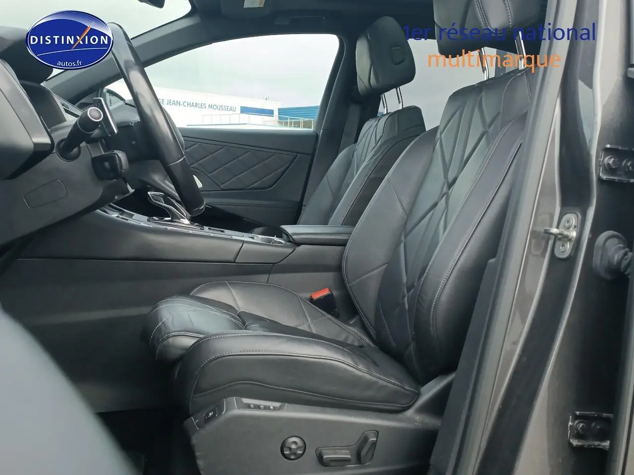 Vue intérieure côté conducteur du DS7 Crossback gris platinium, mettant en valeur les sièges cuir noirs et la console centrale.