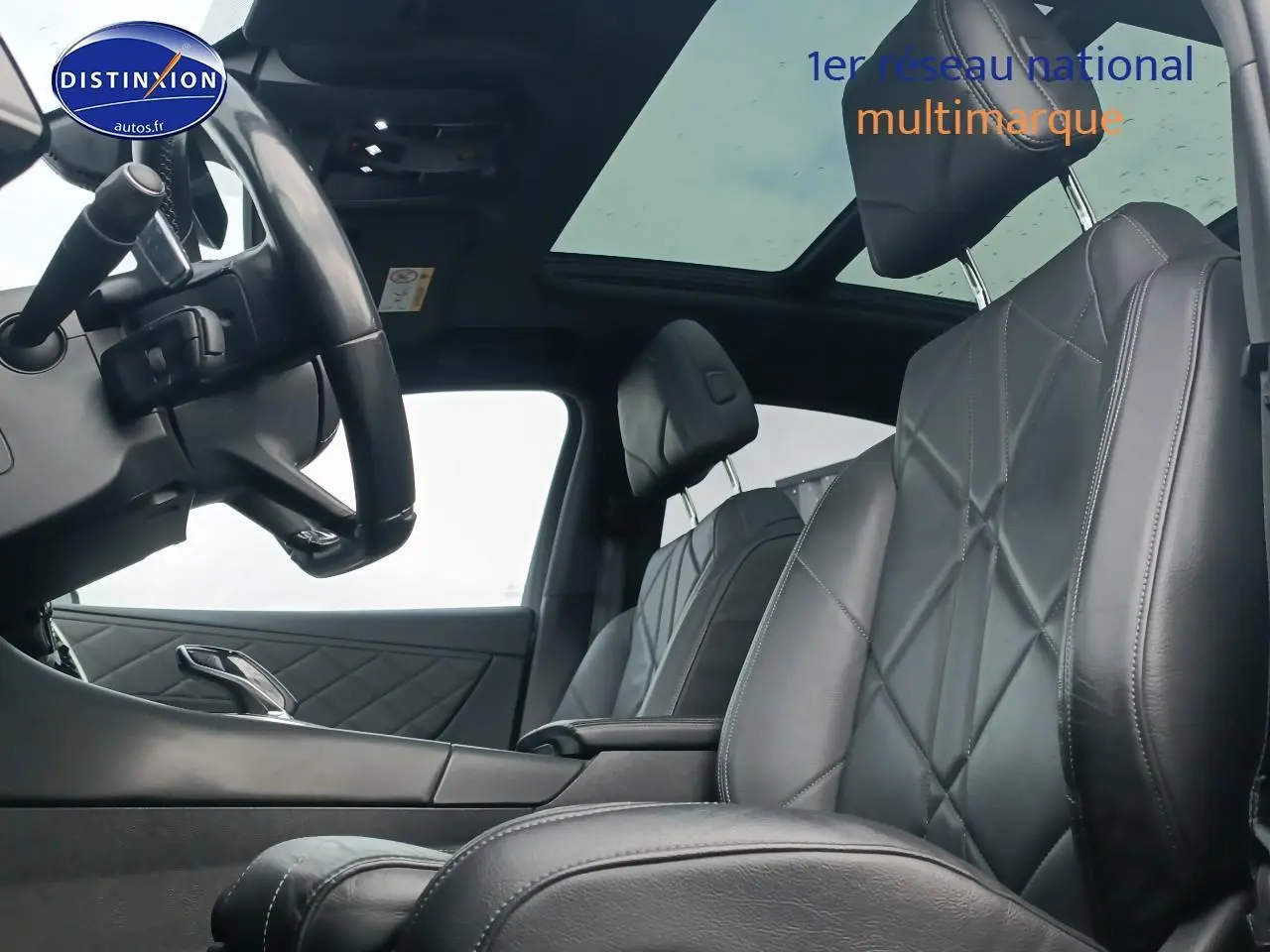 Vue intérieure côté conducteur du DS7 Crossback E-tense 4x4 300 rivoli, sièges cuir noirs et toit panoramique.