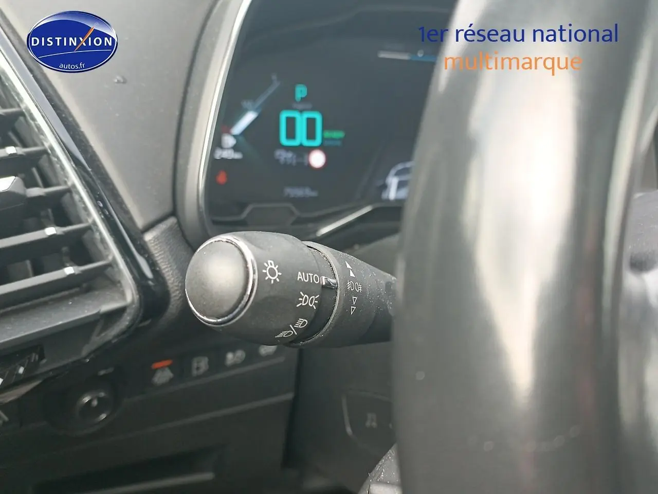 Gros plan sur la commande des phares à gauche du volant dans l’habitacle du DS7 Crossback E-tense gris platinium.