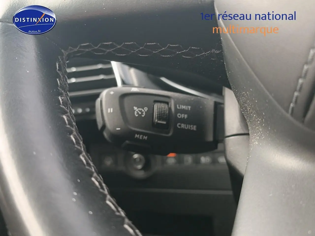 Gros plan sur la commande de régulateur de vitesse derrière le volant cuir du DS7 Crossback gris platinium.