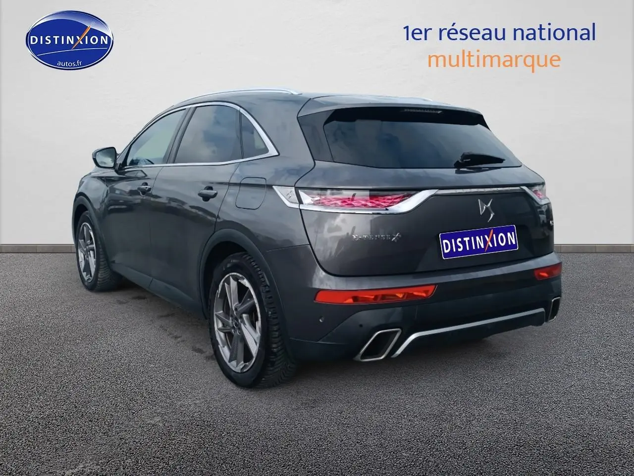 Vue 3/4 arrière droite d'un DS7 Crossback E-tense gris platinium avec feux LED et double sortie d'échappement.