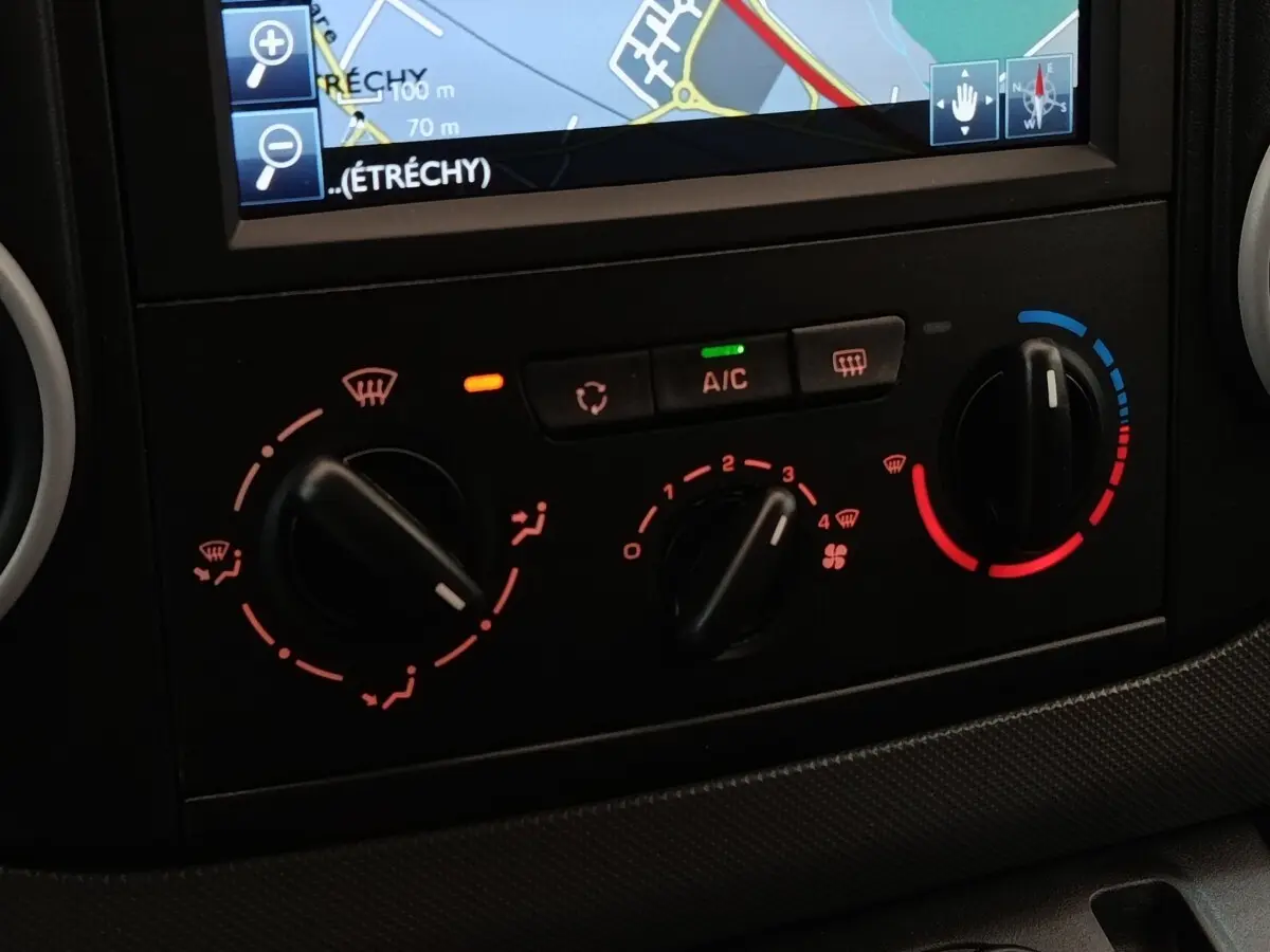 Gros plan sur la console de climatisation et l’écran de navigation du Peugeot Partner blanc, version 1.6 BlueHDi 2018.