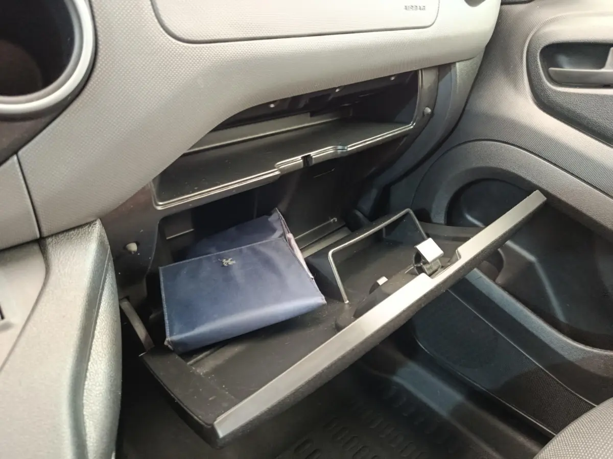 Vue intérieure côté passager du Peugeot Partner 1.6 BlueHDi 2018, boîte manuelle, boîte à gants ouverte avec pochette bleue.