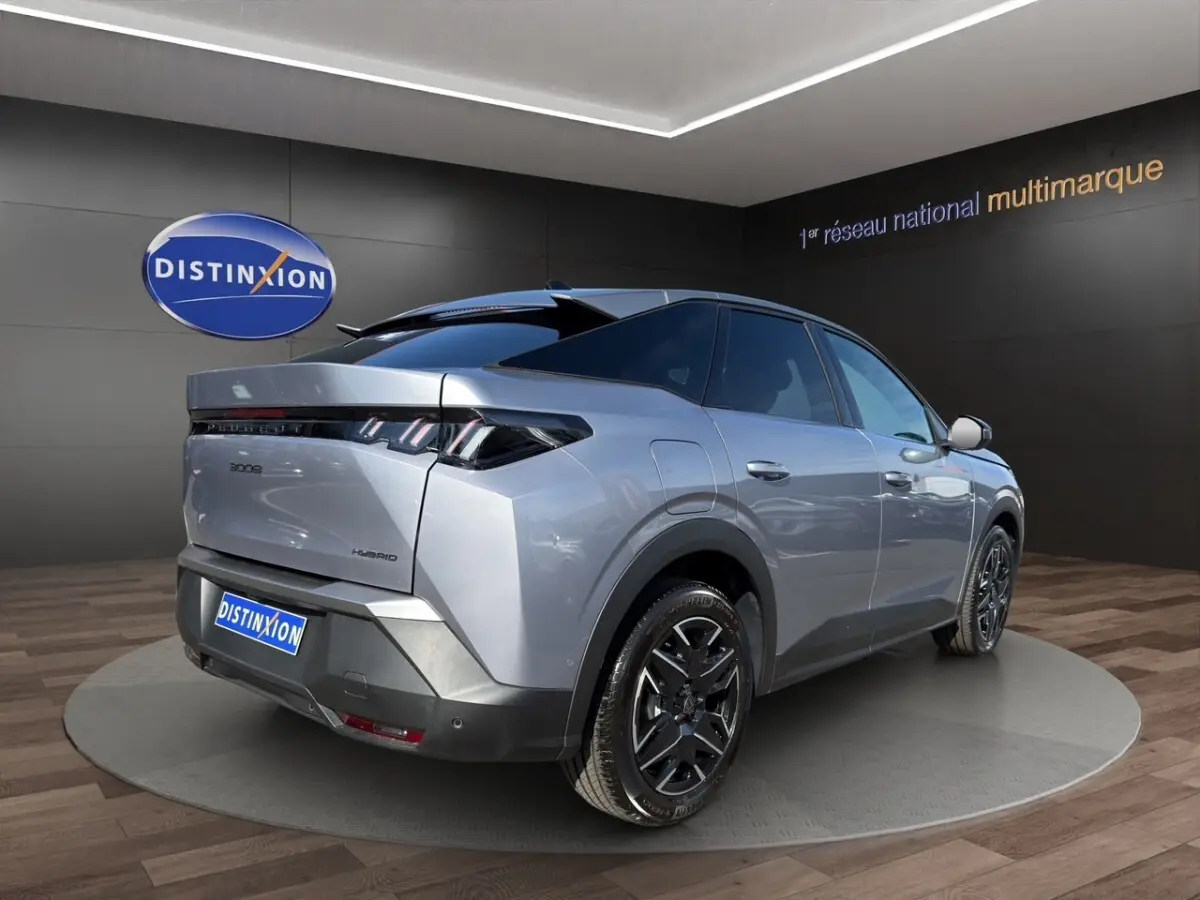 Vue 3/4 arrière droite du Peugeot 3008 hybride gris clair avec jantes noires et feux arrière LED distinctifs.