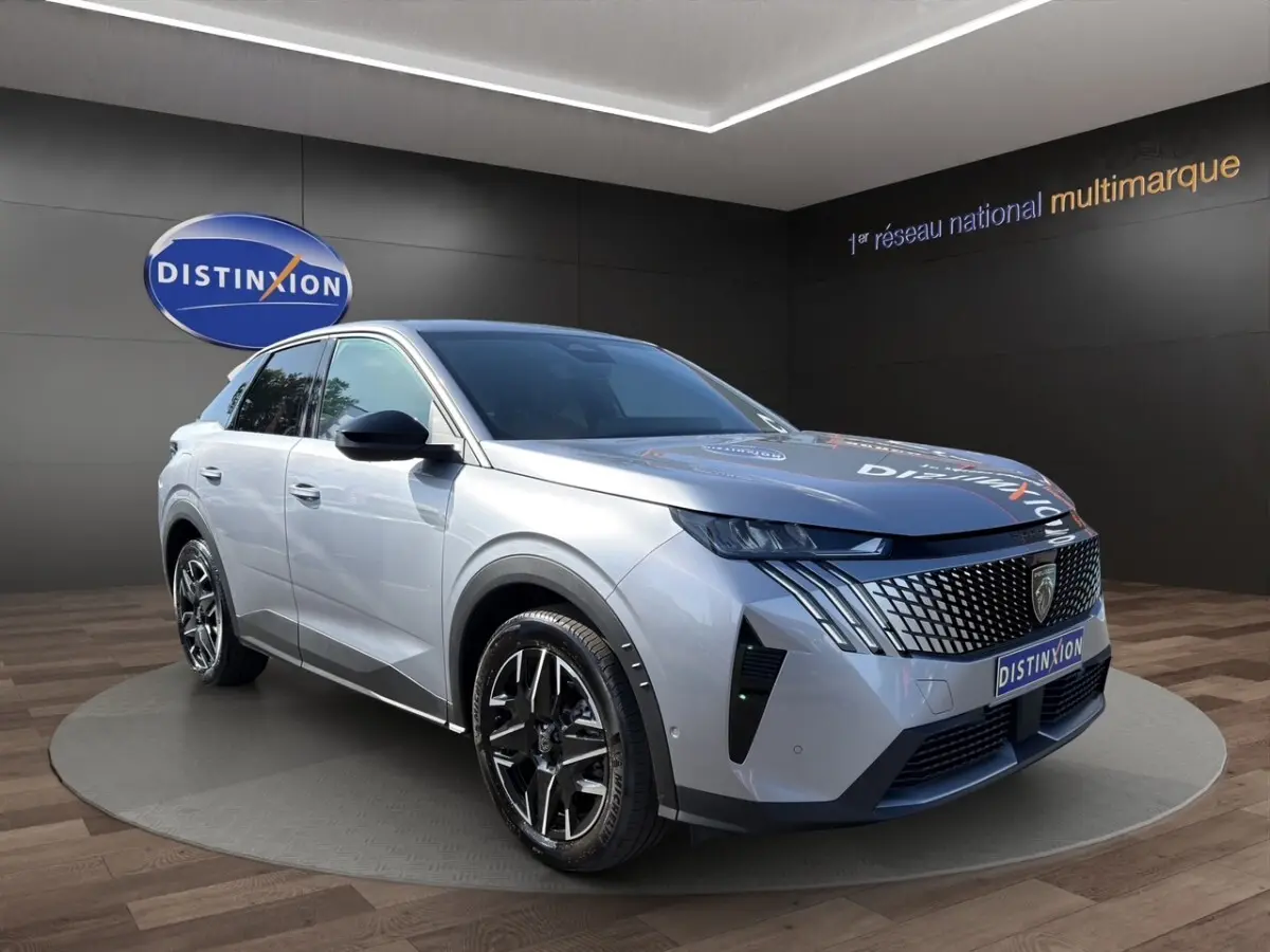Peugeot 3008 gris clair en 3/4 avant droit, avec calandre distinctive et jantes noires en showroom.