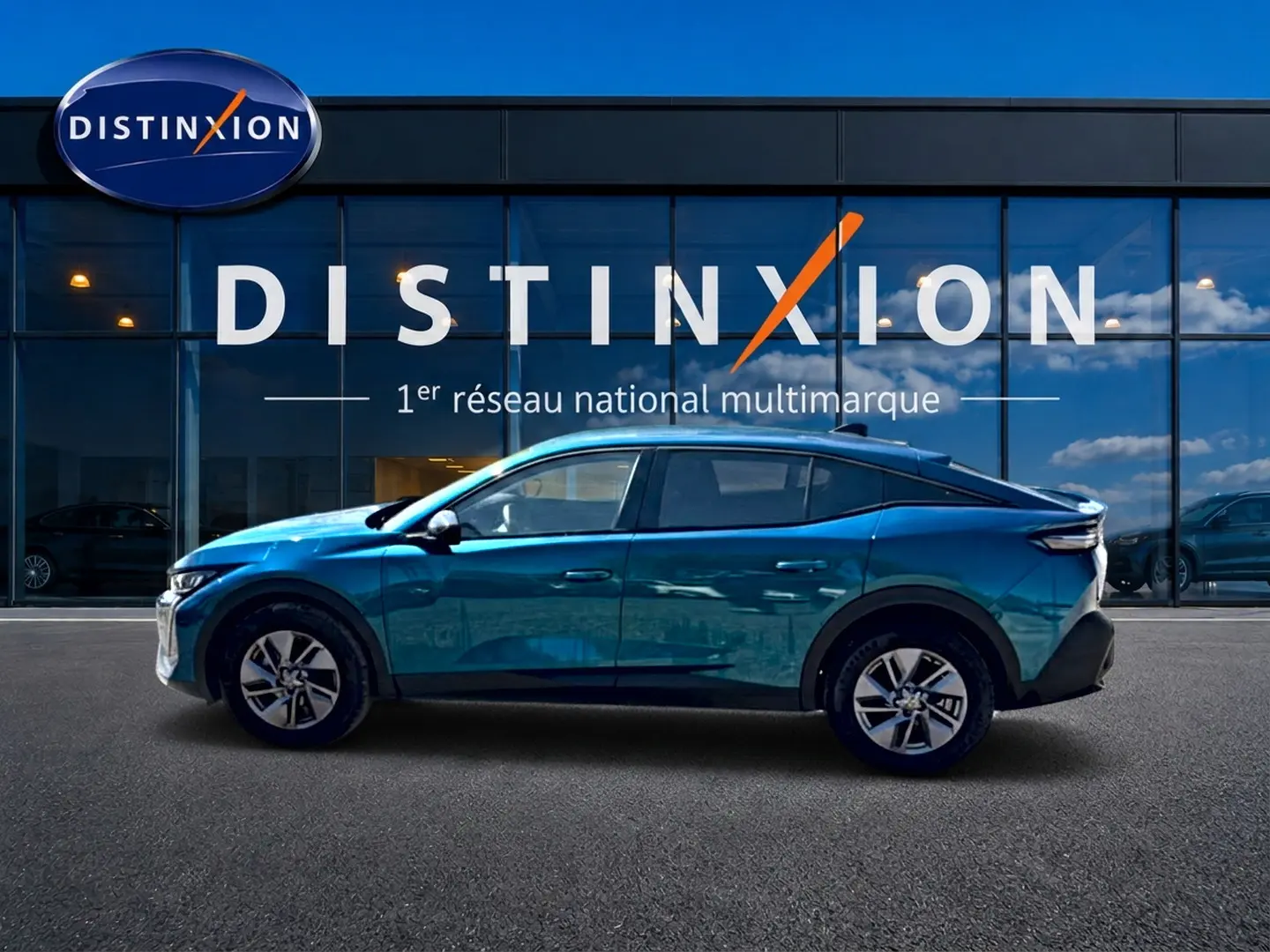 Peugeot 408 Hybrid 145 allure e-dcs6 bleu en profil droit devant une vitrine avec logo Distinxion.