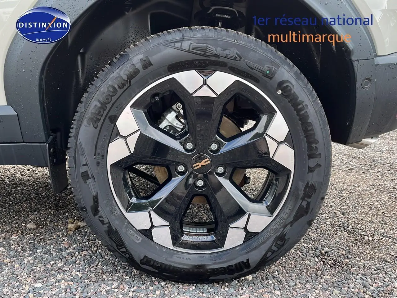 Gros plan sur la roue avant droite du Dacia Duster 2025 Sandstone avec jante alu bicolore et pneu Continental.