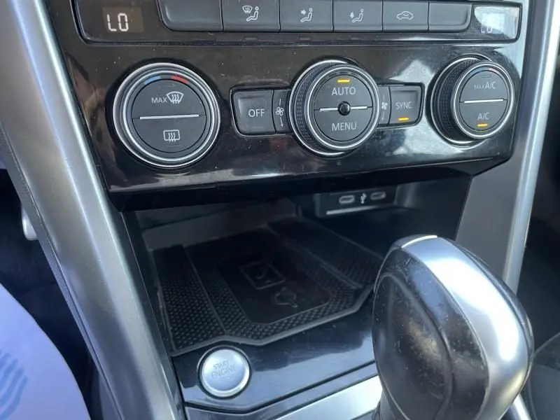 Gros plan sur la console centrale du Volkswagen T-Roc gris foncé, montrant les commandes de climatisation et le levier de boîte automatique.