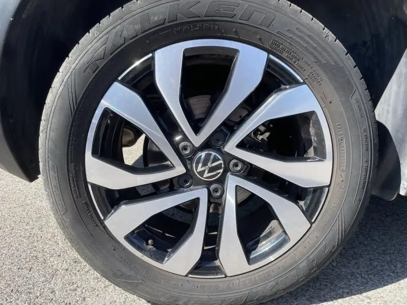 Gros plan sur la jante alliage bicolore du Volkswagen T-Roc gris foncé 2021, mettant en valeur le logo VW central.