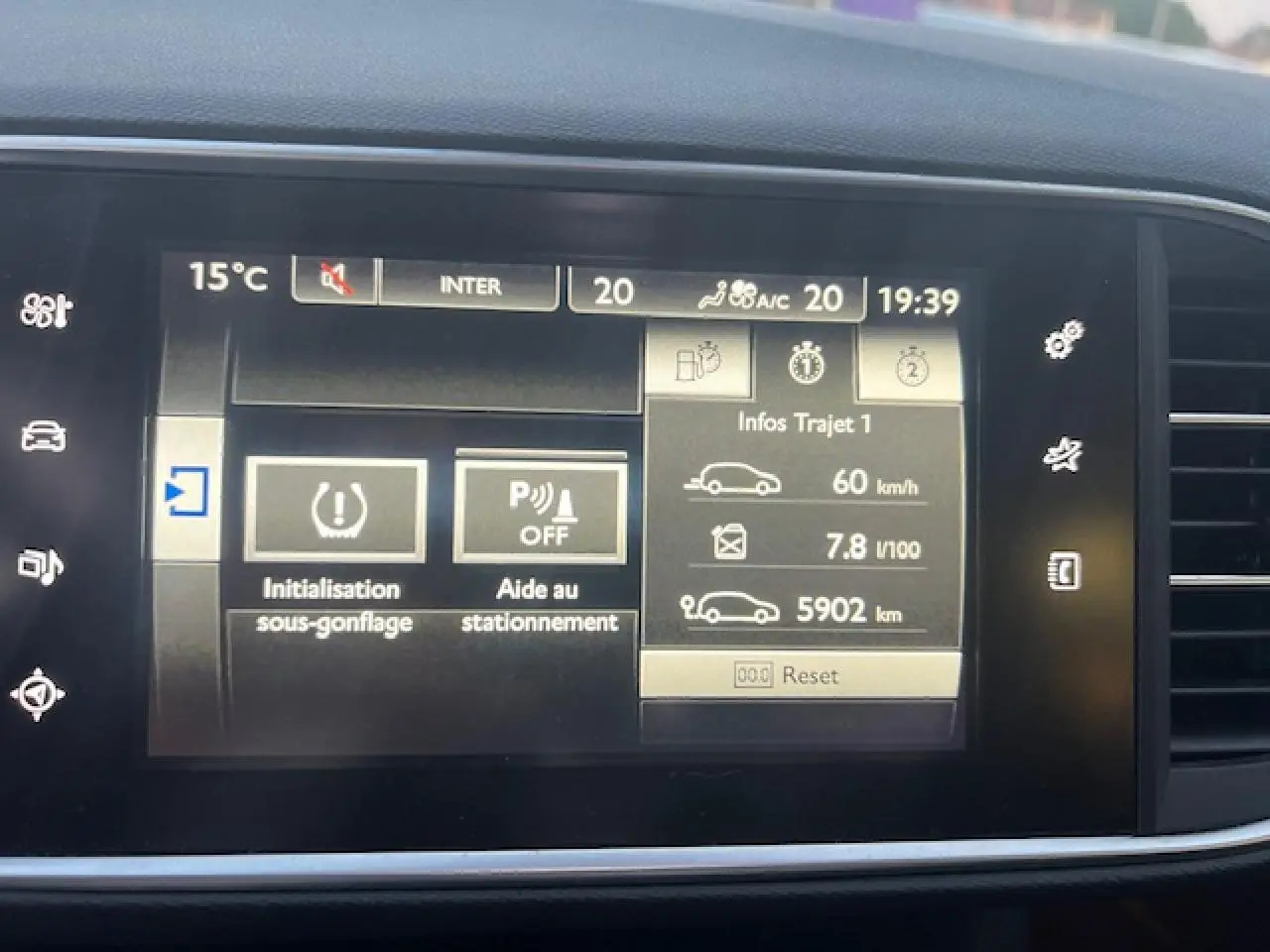 Écran tactile multifonction de Peugeot 308 blanc, affichant l'aide au stationnement et l'initialisation sous-gonflage.