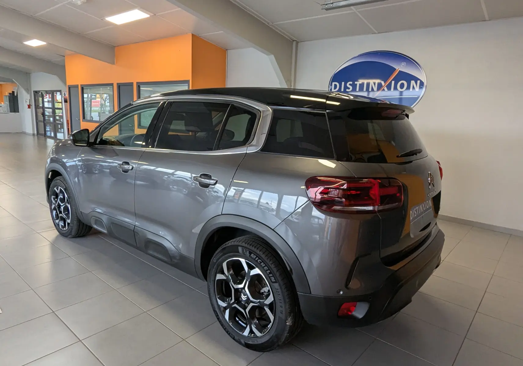 Vue 3/4 arrière droite du Citroën C5 Aircross hybride gris platinium avec toit noir et jantes alliage 18 pouces.