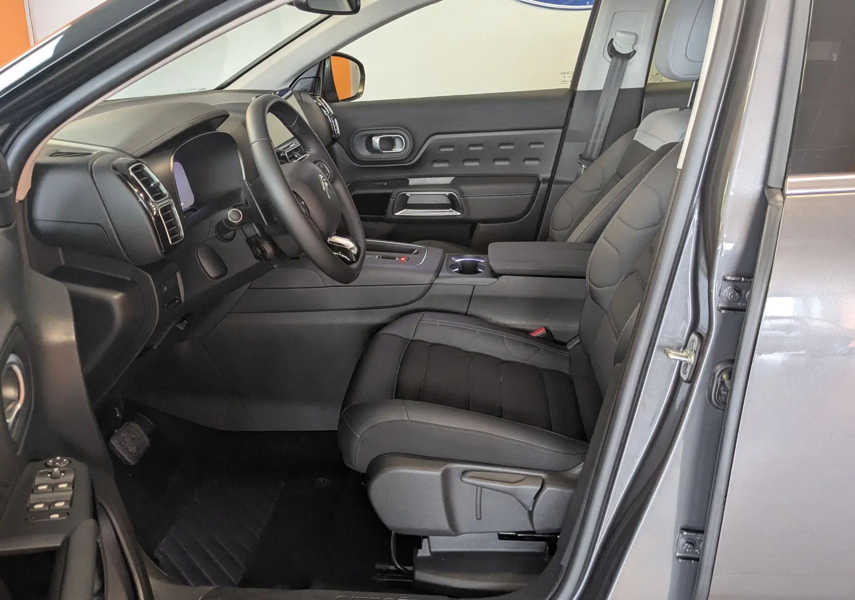 Intérieur côté conducteur du Citroën C5 Aircross gris platinium, sièges tissu effet cuir gris et tableau de bord moderne.
