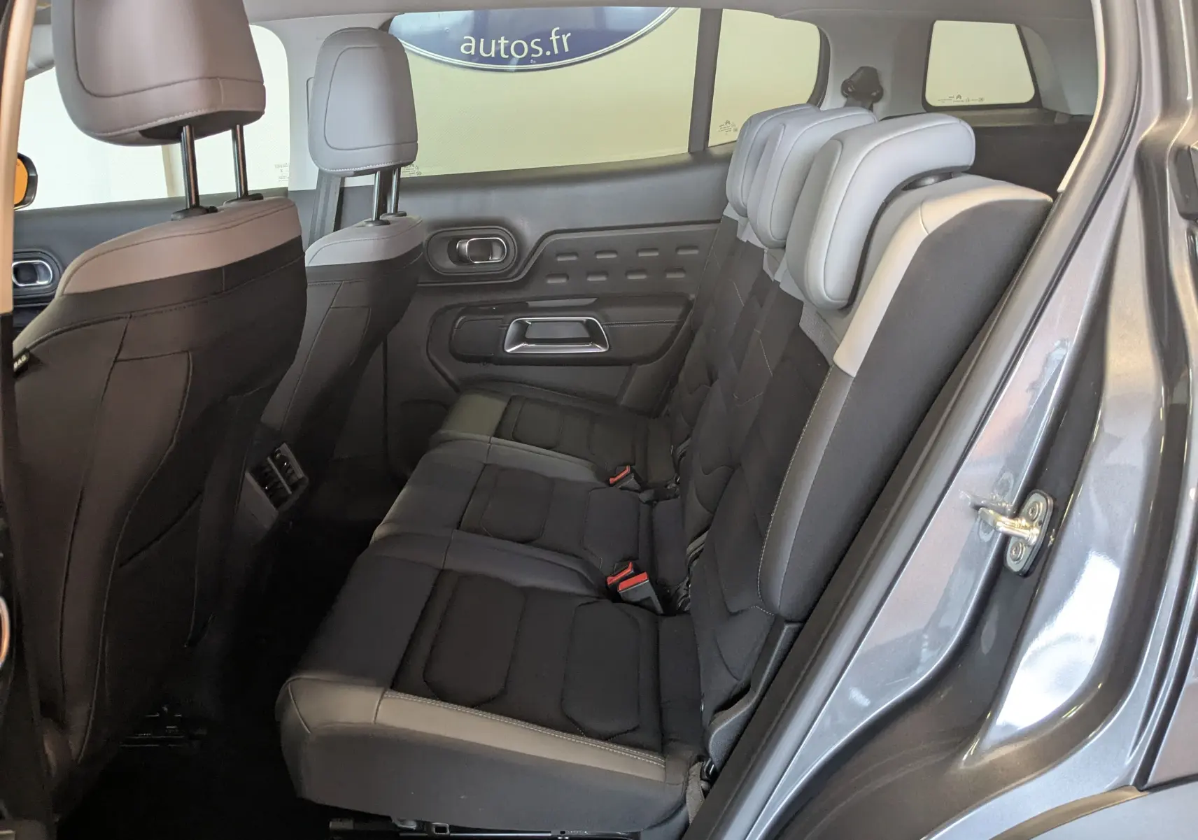 Vue côté droit de l'habitacle arrière du Citroën C5 Aircross gris platinium avec sièges tissu et cuir clair.