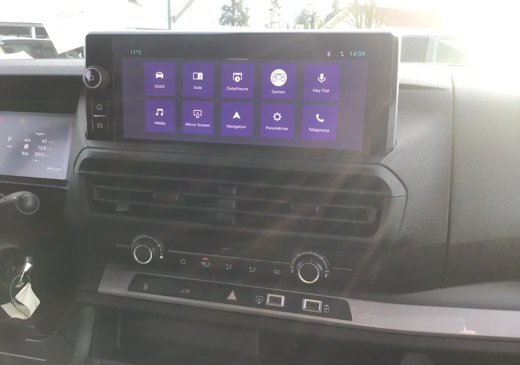 Vue intérieure du tableau de bord du Fiat Scudo Fourgon 2024, avec écran tactile central et commandes climatisation visibles.