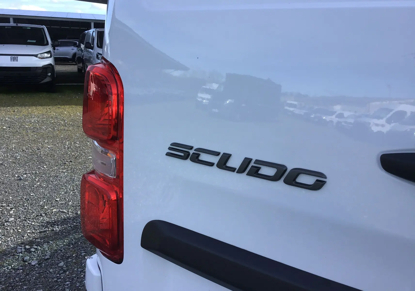 Gros plan sur l'arrière droit blanc du FIAT Scudo Fourgon avec feu arrière rouge et logo Scudo visible.