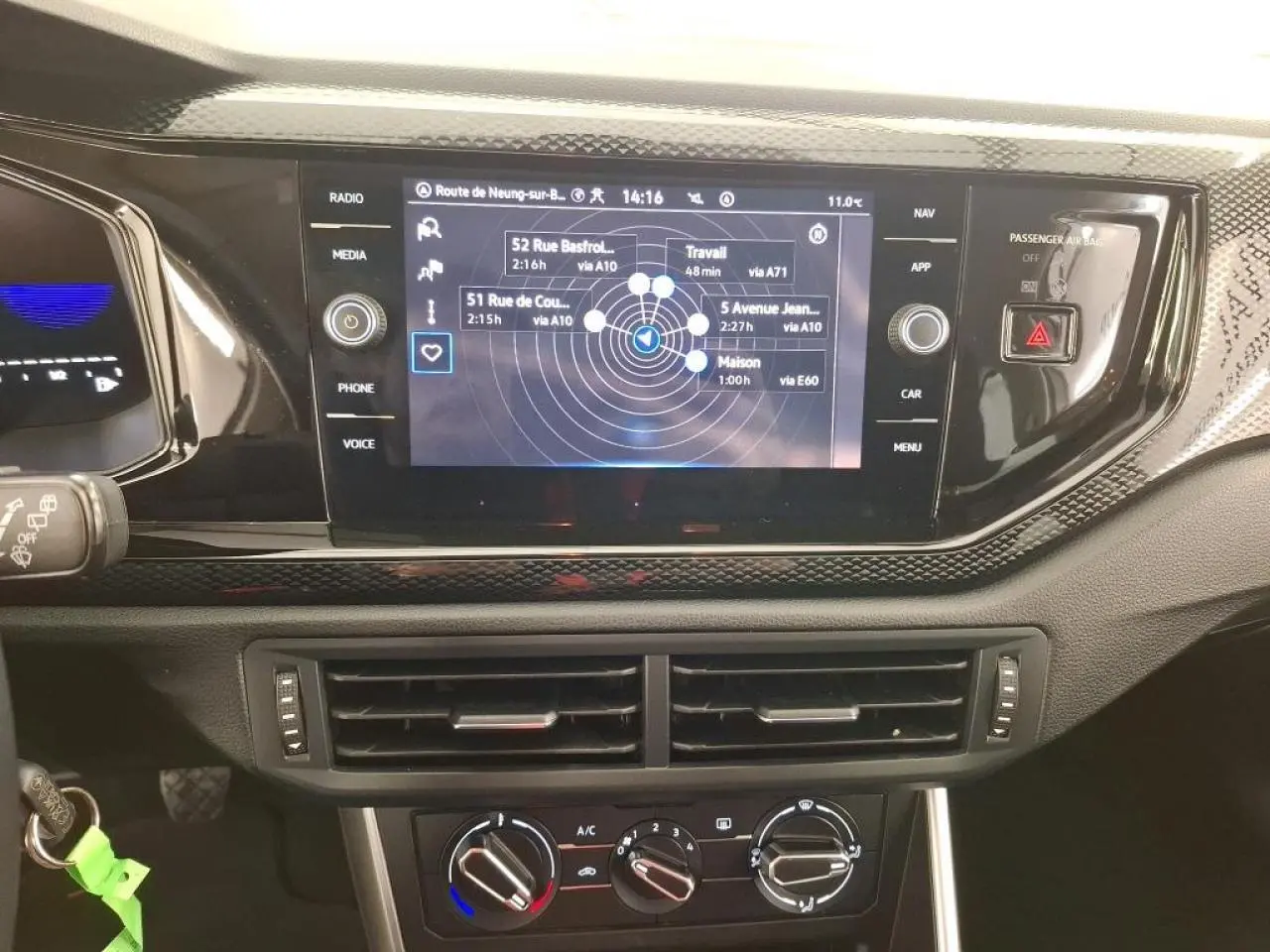 Vue rapprochée du tableau de bord de la Volkswagen Polo 2023 avec écran tactile GPS et commandes de climatisation.