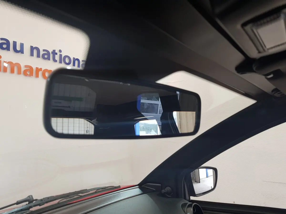 Vue intérieure centrée sur le rétroviseur intérieur et le rétroviseur caméra côté gauche d'une Aixam Ambition rouge 2026.