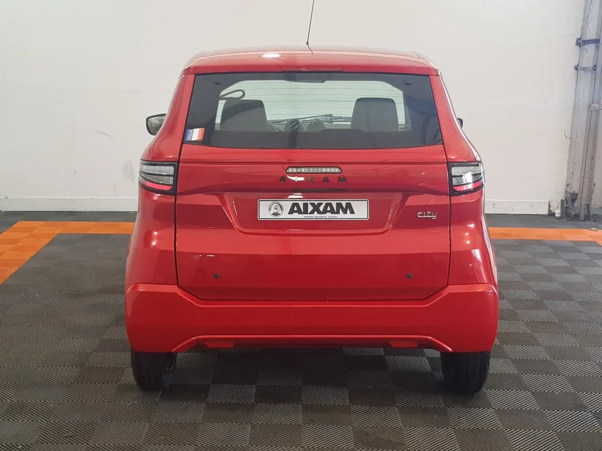 Vue arrière d'une Aixam Ambition 0.5 City Pack rouge 2026 avec logo et feux arrière LED visibles.