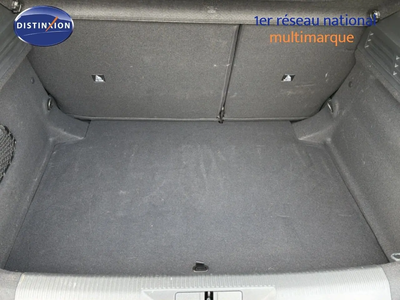 Coffre spacieux de la Peugeot 308 noir métal, vue intérieure montrant le revêtement et les rangements latéraux.