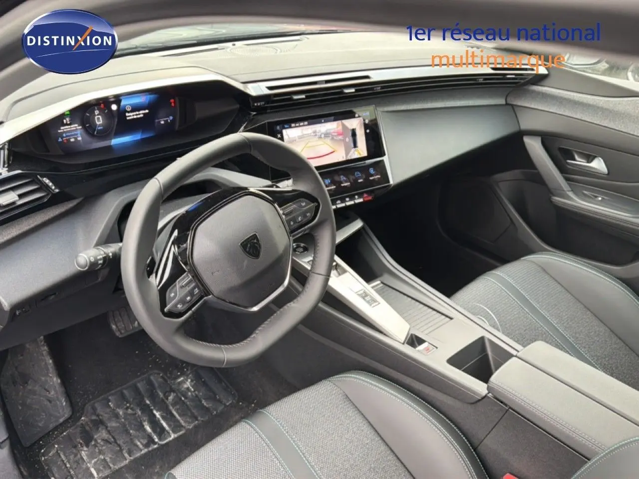 Vue intérieure côté conducteur de la Peugeot 308 hybride 2025 avec tableau de bord numérique et sellerie noire tissu et cuir.