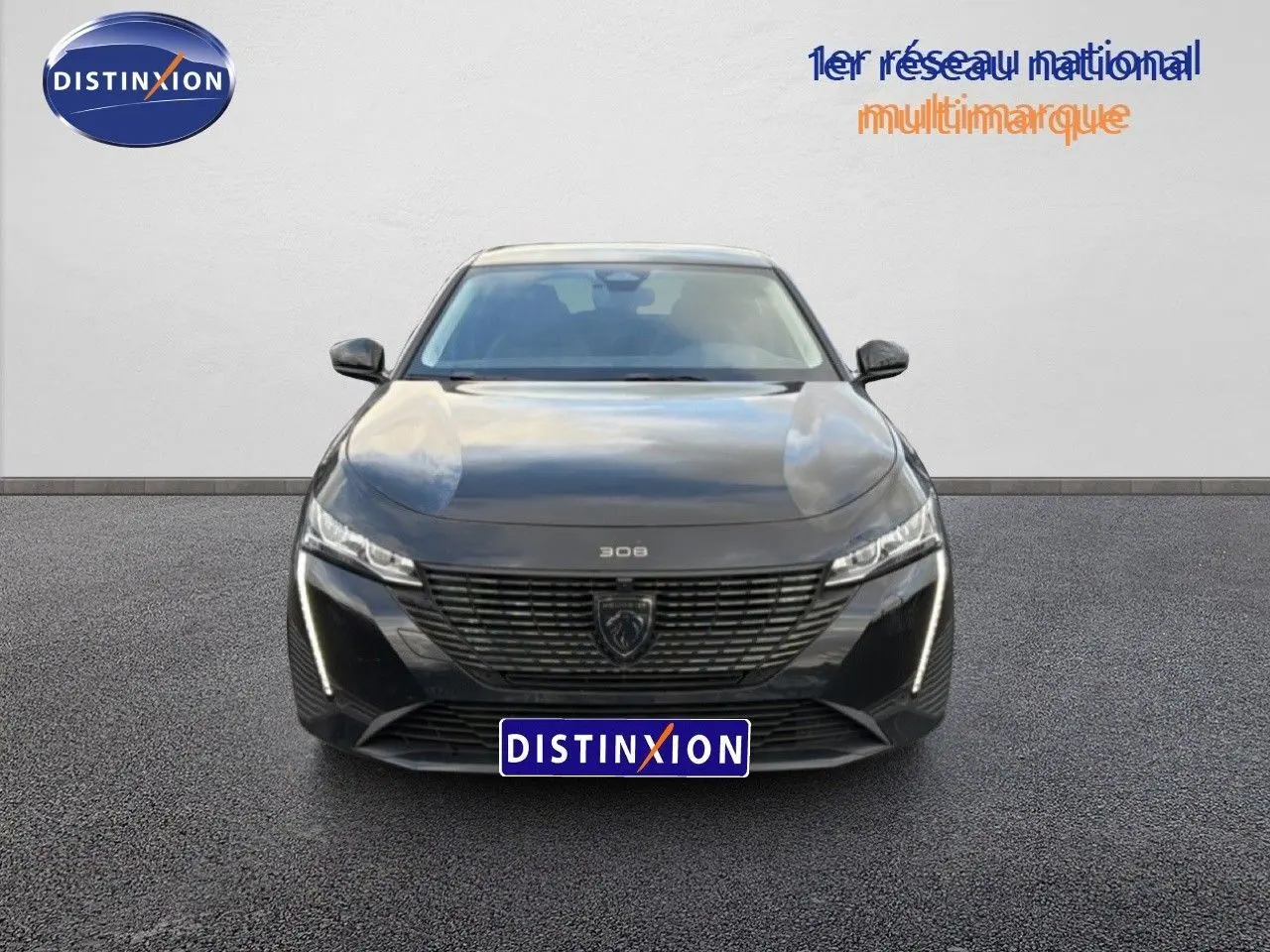 Vue frontale d'une Peugeot 308 1.2 Hybrid 145ch Allure noire métal avec calandre distinctive et feux LED verticaux.