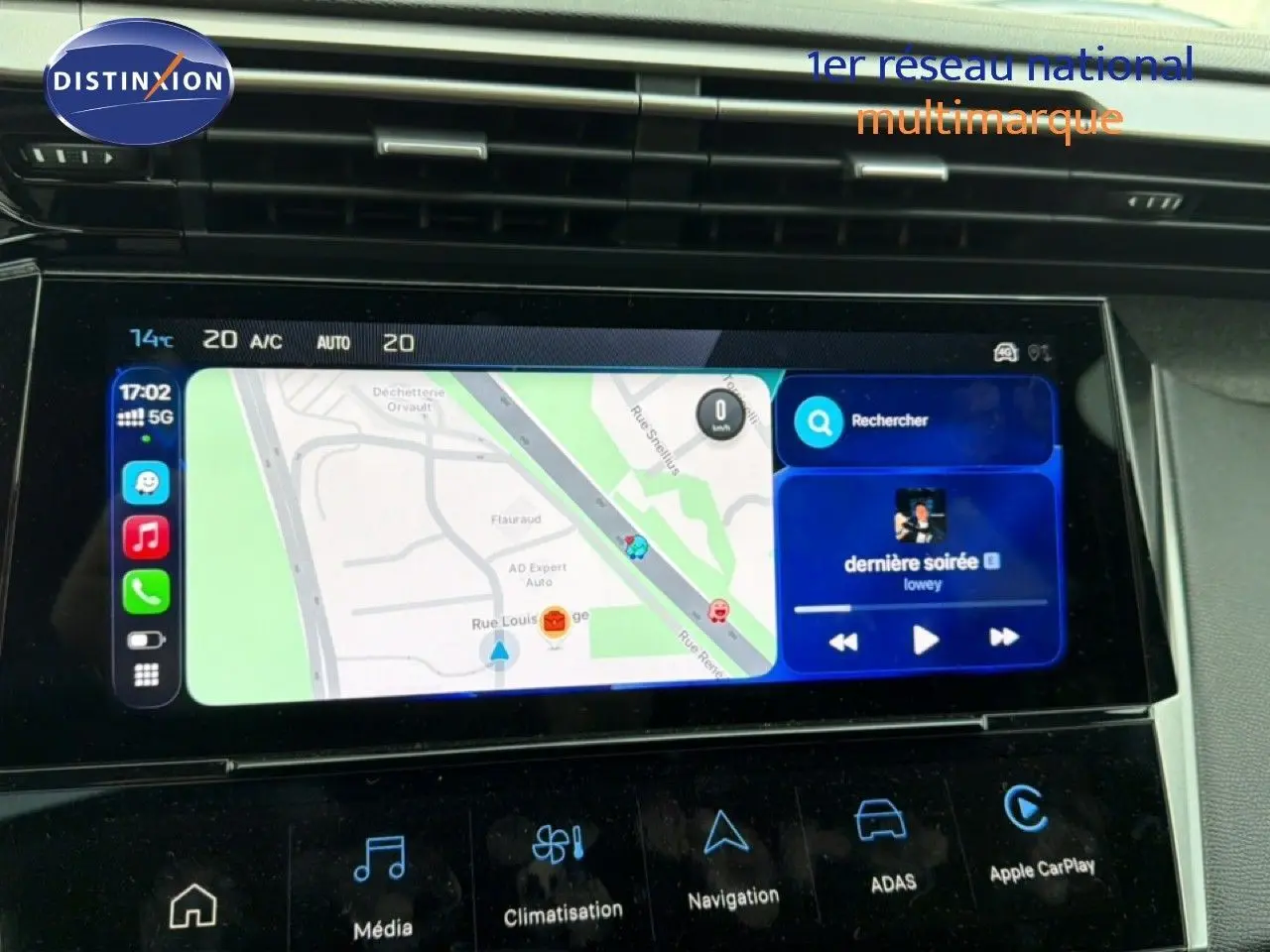 Écran tactile central de la Peugeot 308 noire hybride 2025 affichant navigation et musique, vue intérieure du tableau de bord.