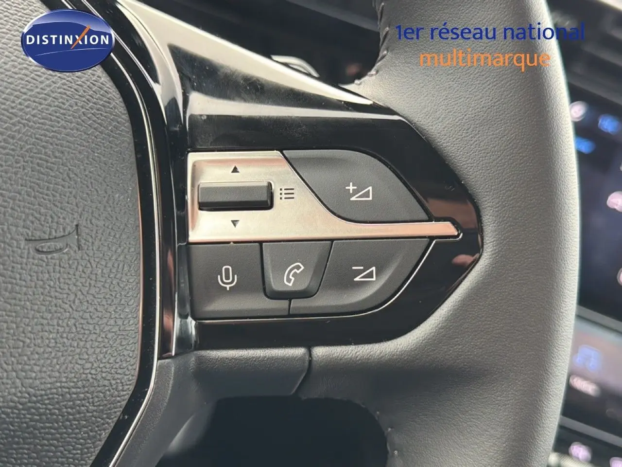 Gros plan sur les commandes multifonctions à gauche du volant cuir noir de la Peugeot 308 1.2 Hybrid 145ch Allure 2025.