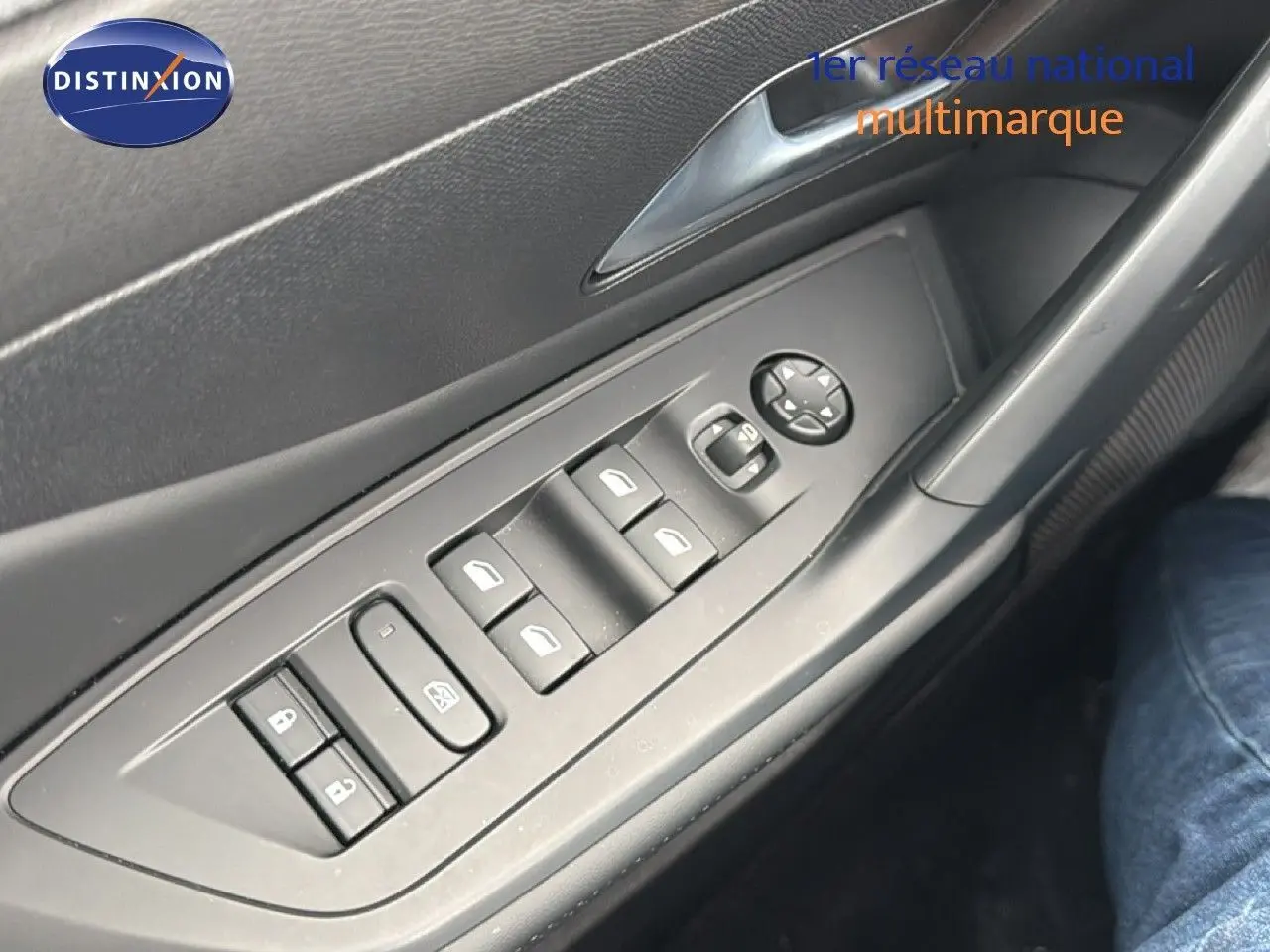 Gros plan sur les commandes des vitres électriques et rétroviseurs sur la porte côté gauche d’une Peugeot 308 noire hybride 2025.